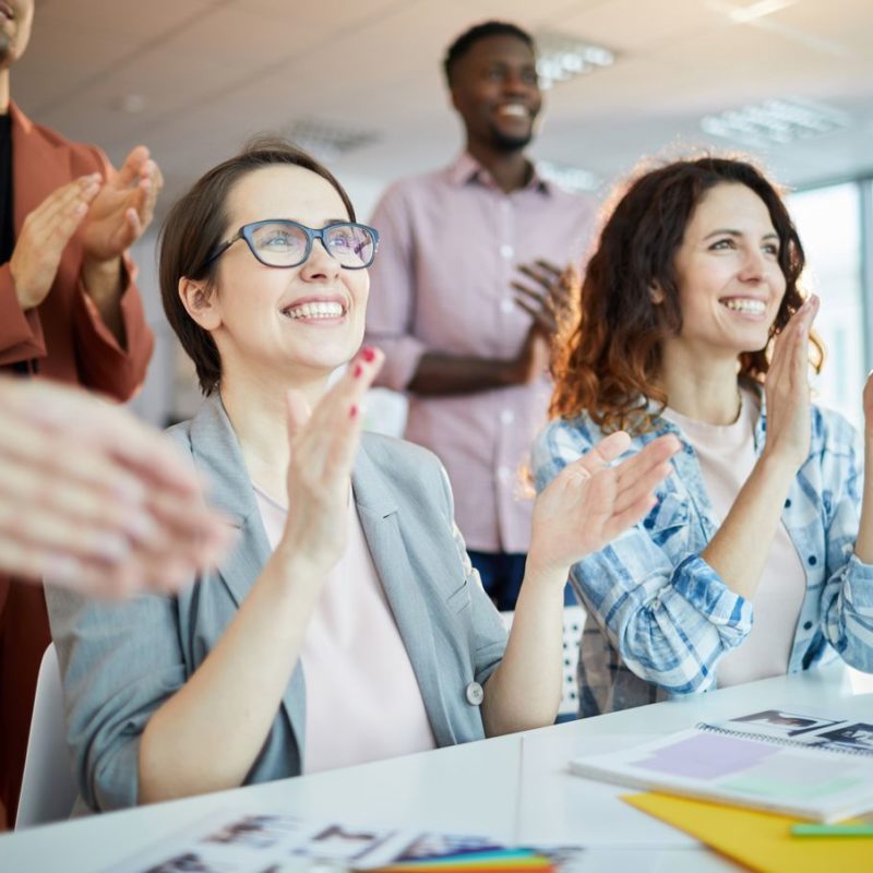 Portrait of multi-ethnic business team clapping happily listening to  presentation in office, copy space